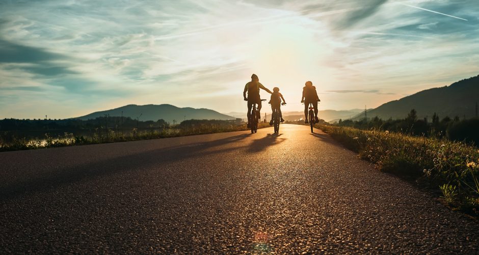 Cyclists,Family,Traveling,On,The,Road,At,Sunset